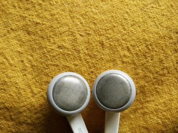 Cropped image of headphones on yellow textile