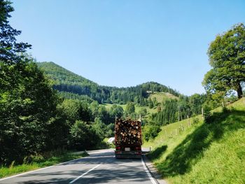 Road amidst trees against clear sky