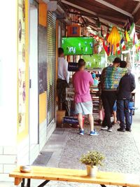 Rear view of people standing at market