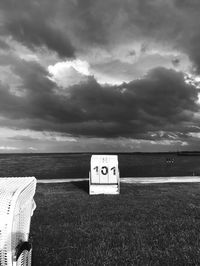 Information sign on beach against sky