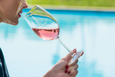 Close-up of woman holding hands in swimming pool