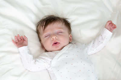 High angle view of baby sleeping on bed