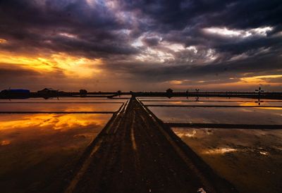 Surface level of road against dramatic sky during sunset