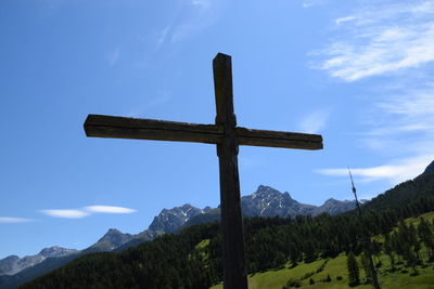 Cross on mountain against sky