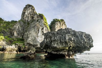 Rock formation by sea against sky