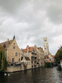Buildings in city against cloudy sky