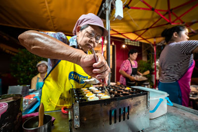 People holding food at market stall