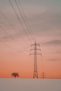 Electricity pylon against romantic sky at sunset