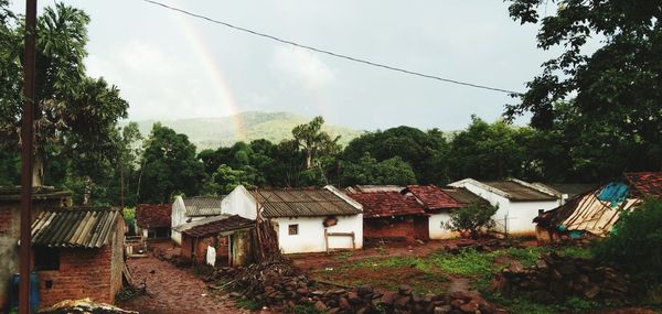Houses amidst trees and buildings against sky