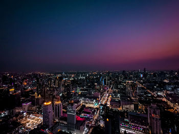 High angle view of illuminated buildings against sky at night