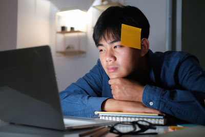 Man using mobile phone while sitting on table