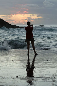 Rear view of silhouette woman standing on beach