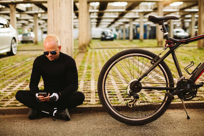 Man sitting by bicycle