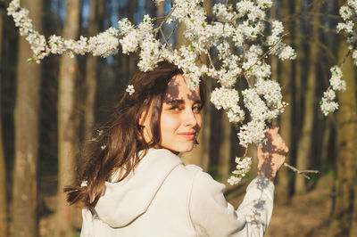 Portrait of young beautiful woman among flowering trees. fashion and beauty. spring concept