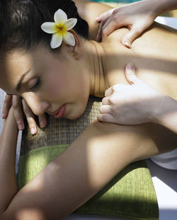 Cropped hands of woman massaging customer at poolside