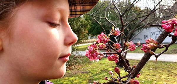 Close-up portrait of woman against pink flowering plants