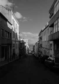 Road amidst buildings in city against sky