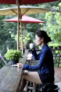 Side view of a young woman drinking coffee