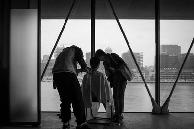 Rear view of people standing against wall