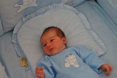 High angle view of child lying in crib