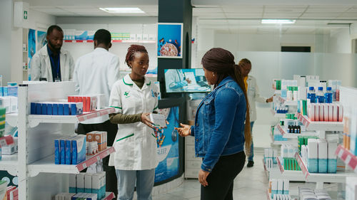 Rear view of female friends standing in laboratory