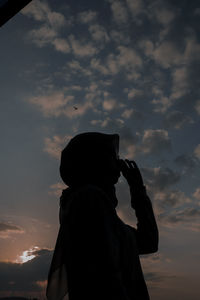 Silhouette man standing against sky during sunset