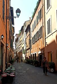 People walking on street amidst buildings in city