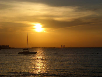 Sailboats in sea against sky during sunset