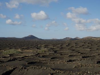 View of desert against cloudy sky