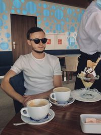 Man and coffee cup on table