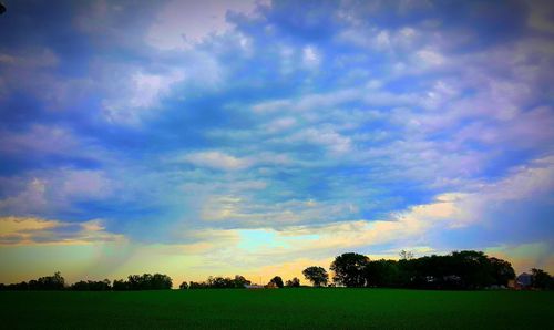 Scenic view of field against cloudy sky