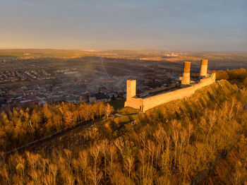 Aerial view of city buildings against sky during sunset