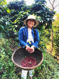Portrait of smiling woman standing by plants