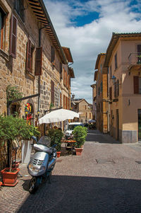 Overview of an alley with old buildings and scooter in orvieto, italy.