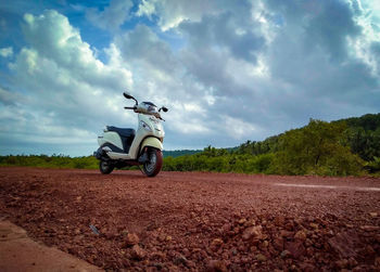 Motorcycle on road by land against sky