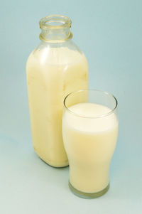 Glass of bottle against white background