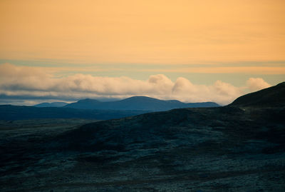 Scenic view of dramatic landscape against sky during sunset