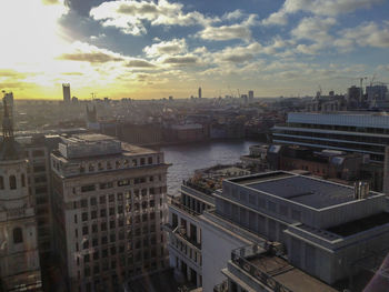 High angle view of buildings by river against sky