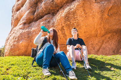 Low angle view of woman sitting on rock