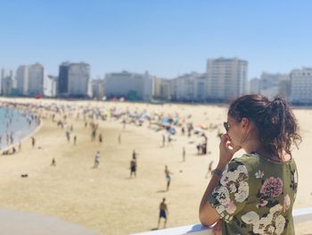 Woman on beach against sky in city