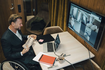 High angle view of disabled businessman with discussion on video call during covid-19