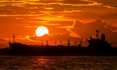 Scenic view of sea against orange sky