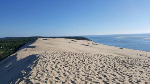 Scenic view of beach against clear blue sky