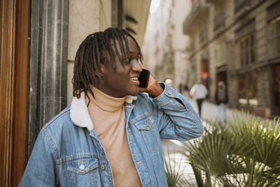 Portrait of young man looking away in city