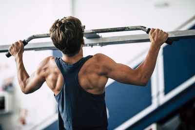 Rear view of male teenager exercising