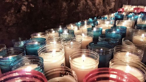 Close-up of lit candles in glass jar