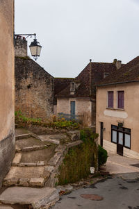 Old building by street against sky