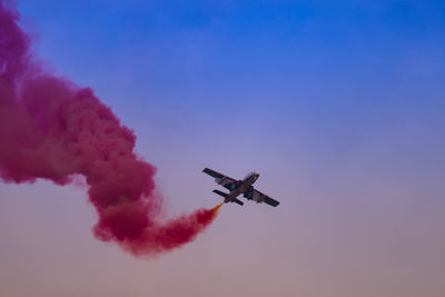 Low angle view of airplane in mid-air against sky