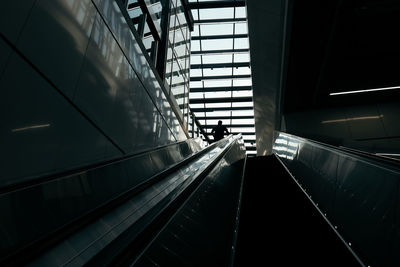 Low angle view of man standing on escalator