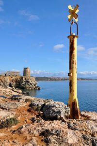 Lighthouse by sea against sky